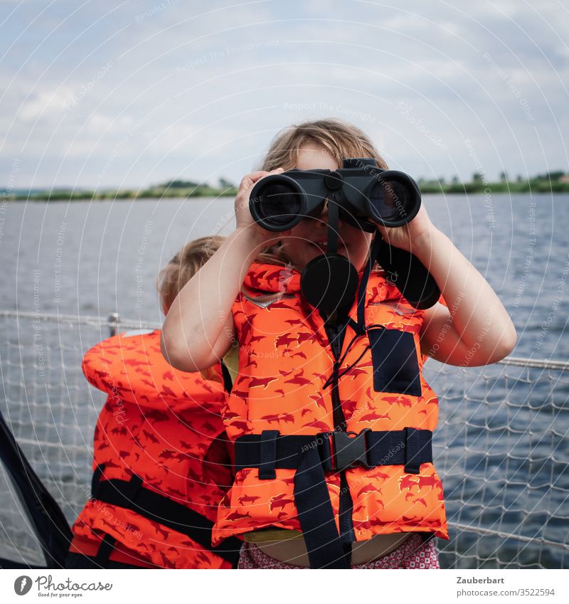 Girl with life jacket and binoculars on sailboat Child girl Sailing Binoculars Sailboat Water Ocean Coast Life jacket Orange Summer Yacht vacation