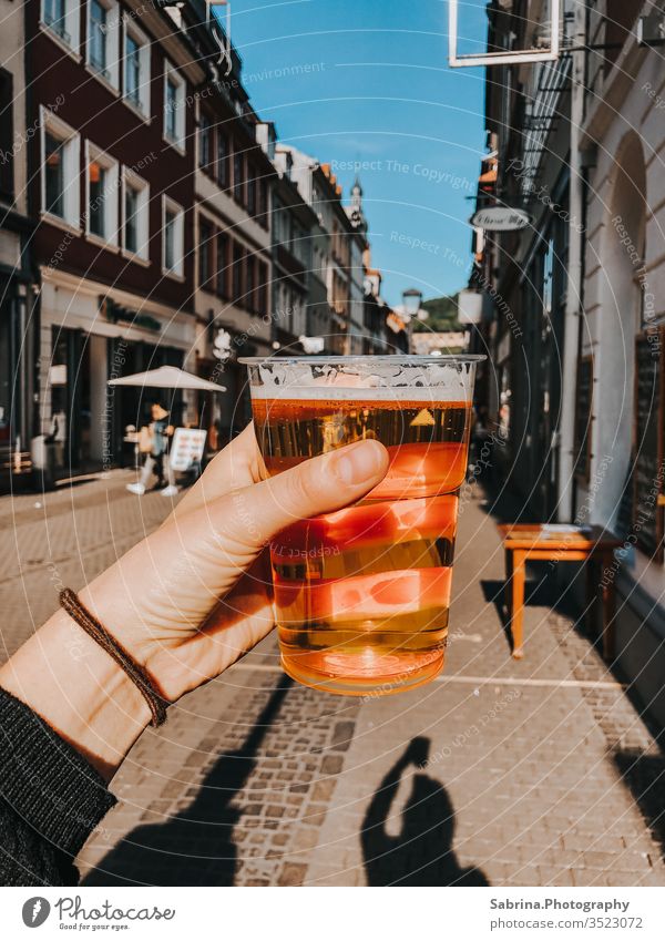 Full beer glass in the main street in Heidelberg Beer Mug Street Main street Town Downtown Beer glass Tourism Old town Baden-Wuerttemberg Europe Germany by hand