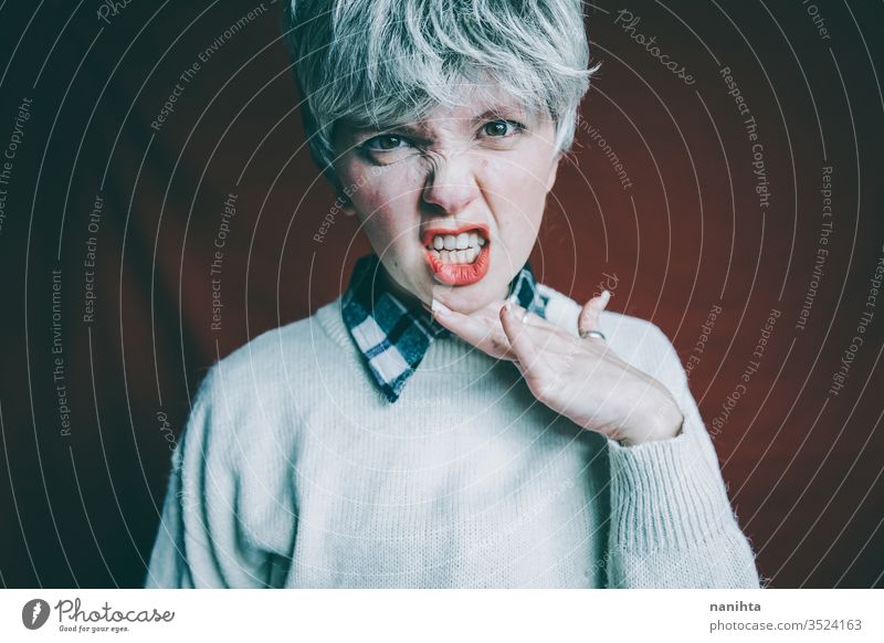 Portrait of a really angry androgynous woman rage rude sign expressive furious emotional mood portrait portraiture short hair red hair finger loud scream