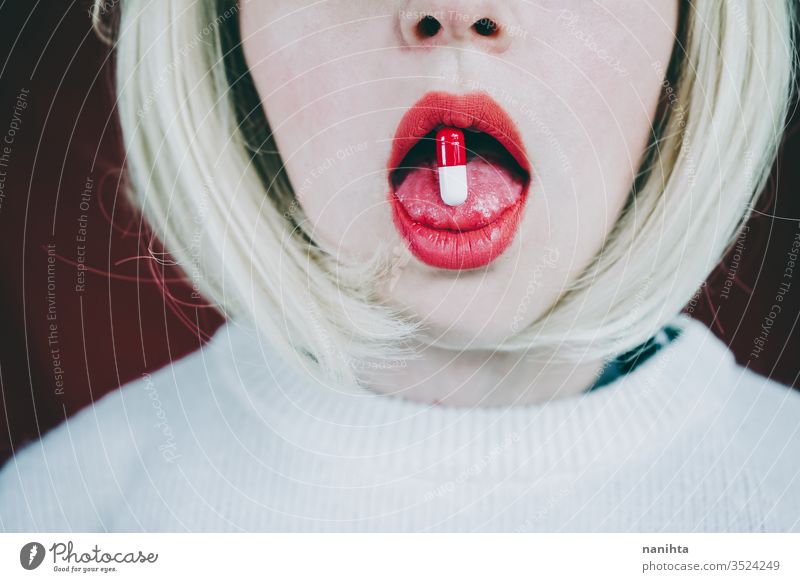 Conceptual image about drug addict with a pill in a young woman tongue addiction mouth medicine painkiller pain killler anestesic medical treatment lick sexy