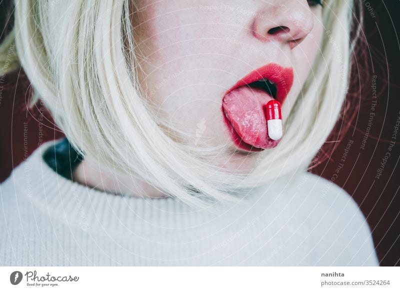 Conceptual image about drug addict with a pill in a young woman tongue addiction mouth medicine painkiller pain killler anestesic medical treatment lick sexy