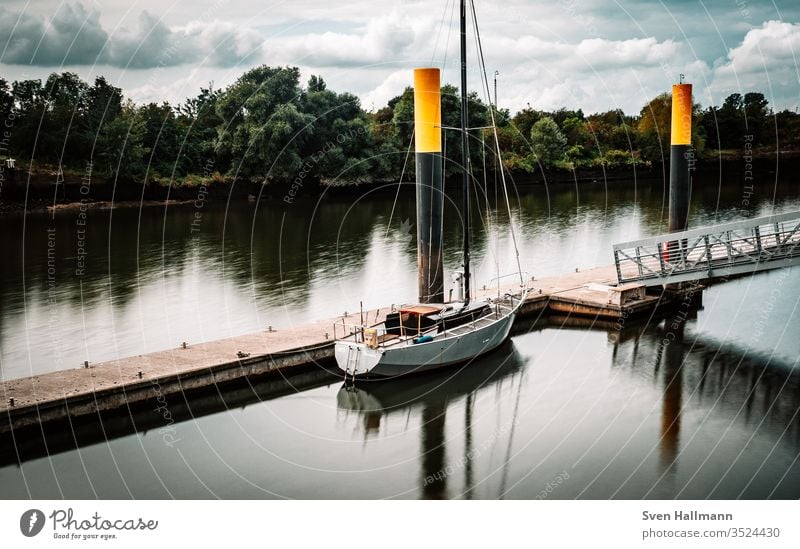 lonely boat in the harbor Sailboat Sailing Yacht Sky Water vacation Freedom Sailing ship Adventure Exterior shot Vacation & Travel Summer Colour photo Aquatics