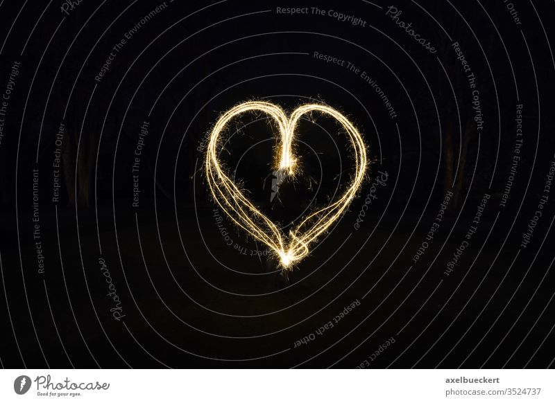 heart shape light painting with sparklers painting with light love symbol fire sign sparks fireworks glow romance romantic dark night outside black valentine