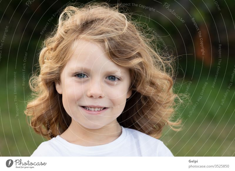 Funny blond kid with long hair child outside one childhood people caucasian joy boy little nature wavy play summer young outdoor fun happy playful lifestyle