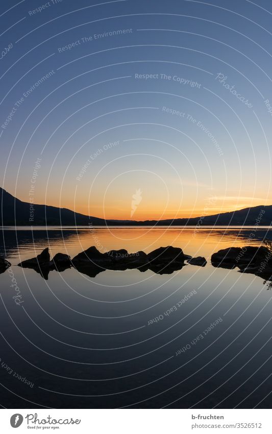 Twilight at the lake Dusk Evening evening light stones Calm tranquillity Lake moon lake relaxation Meditation Shadow Moody evening mood Sunset Sky Nature