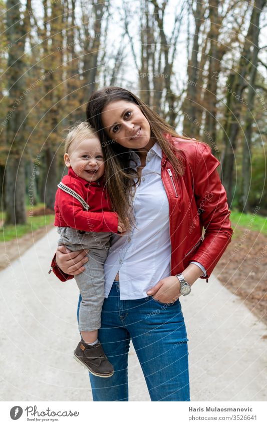 Happy family, young mother holding 1 year old child and smiling 1 year old baby adult autumn beautiful caucasian combination cute fall family day fashion female