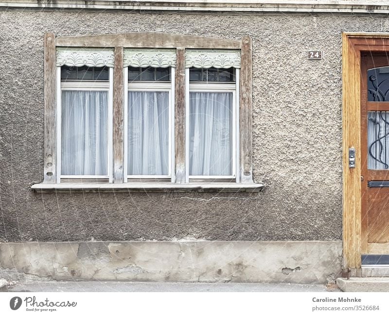 Three windows next to a house entrance Window door Architecture House (Residential Structure) Old squiggled waivers Manmade structures built Deserted