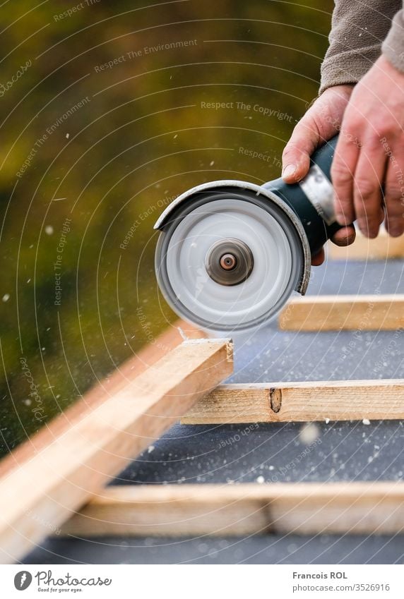 construction worker on a renovation roof covering it with tiles using hammer, crane and grinder artisan builder built carpenter chimney condominium coverage