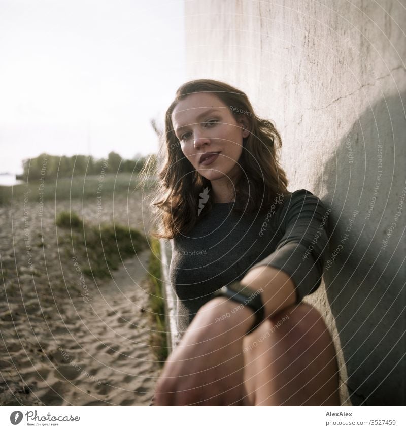 analogue portrait of a young woman in a dress in front of a wall Woman girl already great Athletic Slim fit brunette Curl long hair Wall (building) Concrete