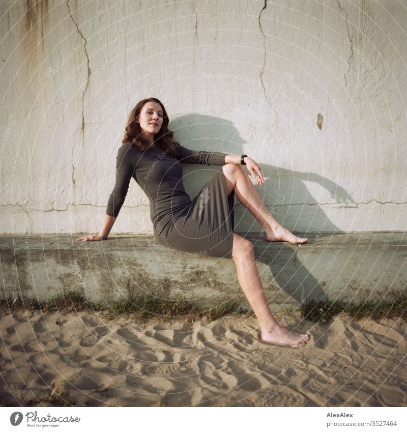 analogue portrait of a young woman in a dress in front of a wall Woman girl already great Athletic Slim fit brunette Curl long hair Wall (building) Concrete