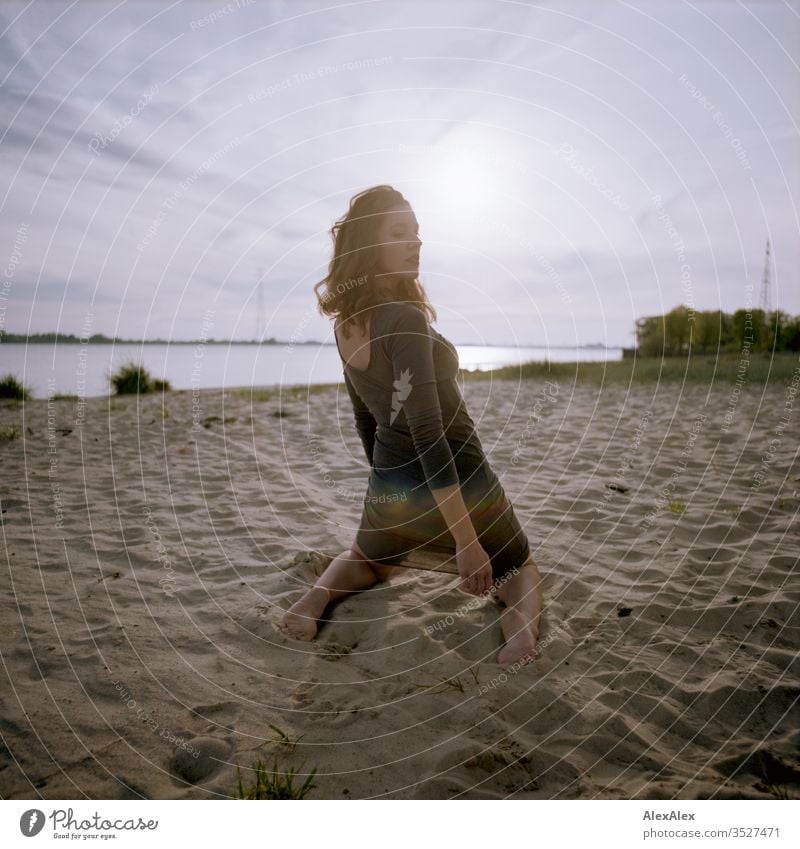 analogue backside portrait of a young woman in a dress on the beach at sunset Woman girl already great Athletic Slim fit brunette Curl long hair Concrete Sand