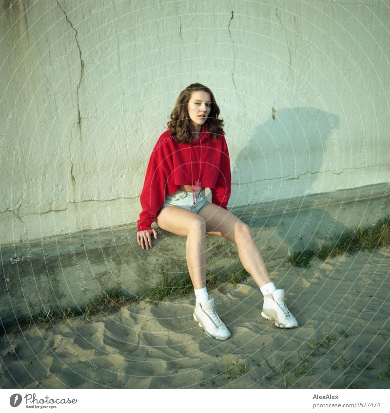 analogue portrait of a young woman with red hoodie and hot pants Woman girl already great Athletic Slim fit brunette Red Hot pants Curl long hair sneakers Legs