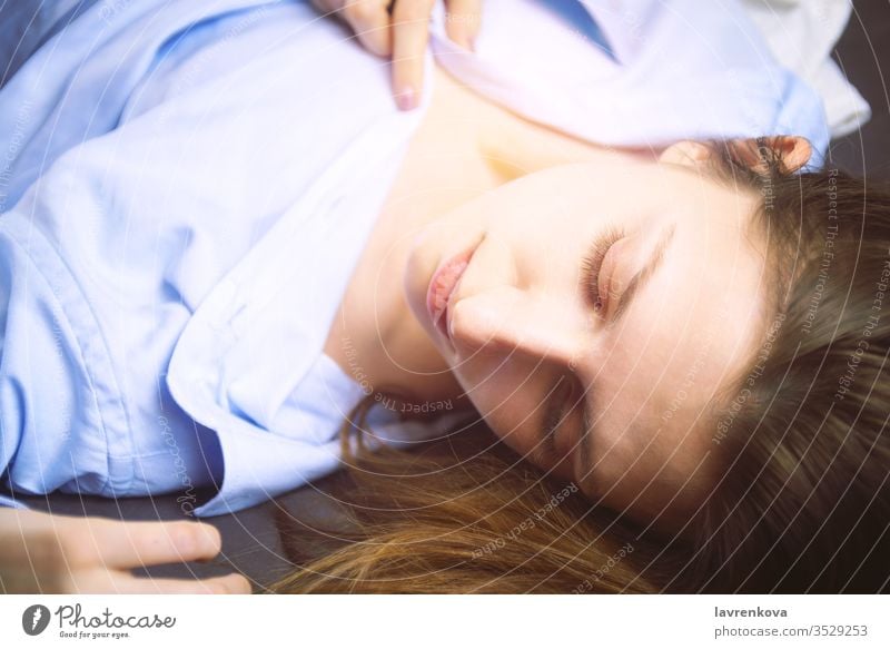 Closeup of young beautiful woman in blue lying in bed. Natural beauty. Selective focus. Film style romantic relaxation spa face body health treatment selective