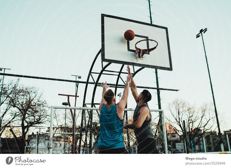 Young basketball players playing one-on-one. game youth sport court male young team together active action playground exercise men friendship jump happy athlete