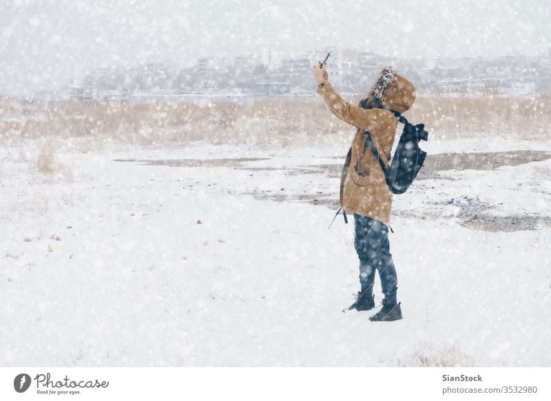 woman is taking photo in snowy landscape winter walking phone selfie takes smartphone mpbile cold outdoor step white nature fashion scene park girl beautiful