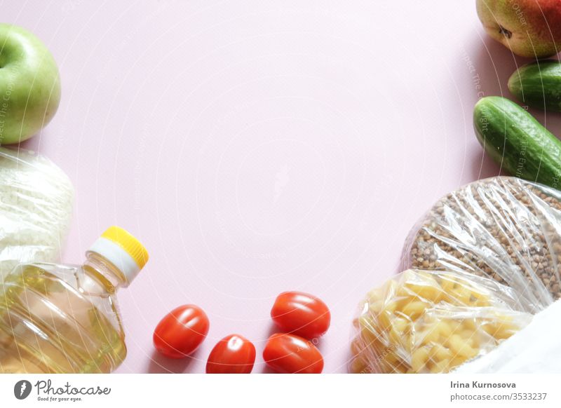 Paper bag of different health food on a pink background. Top view. Flat lay with fruits, vegetables, rice and buckwheat. apple balanced buying cucumber diet