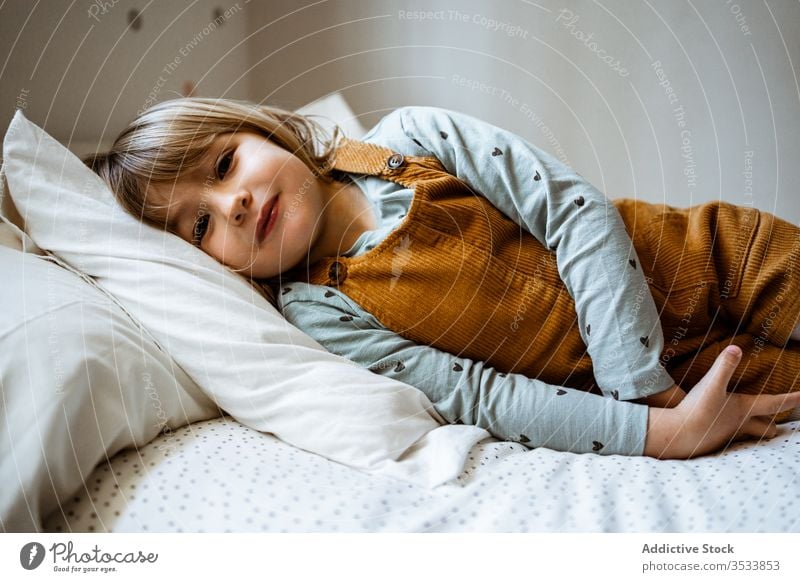 Cute girl looking at camera home cozy rest cute casual calm portrait little outfit adorable kid room childhood relax innocent domestic blond harmony tranquil