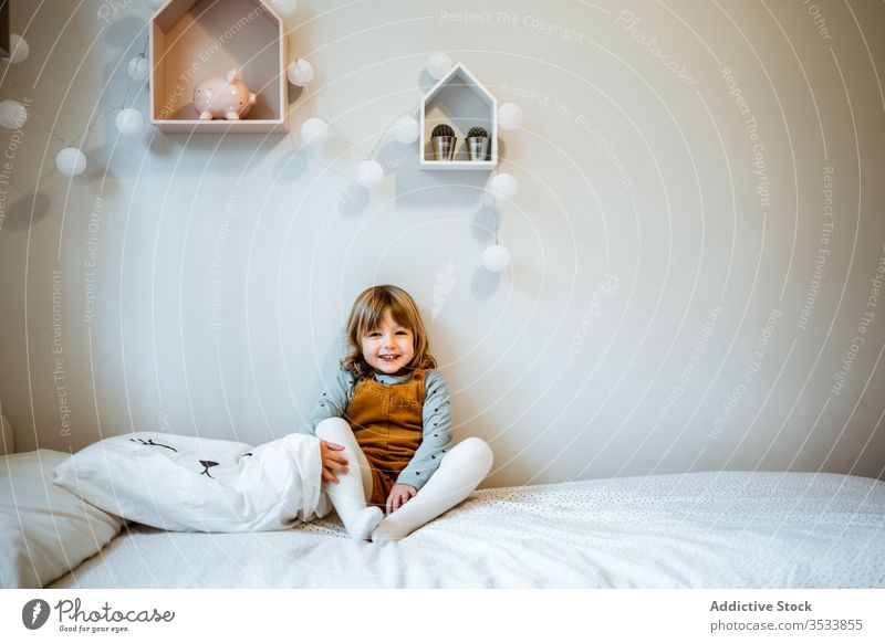 Cute girl looking at camera home cozy rest cute casual calm portrait little outfit adorable kid room childhood relax innocent domestic blond harmony tranquil