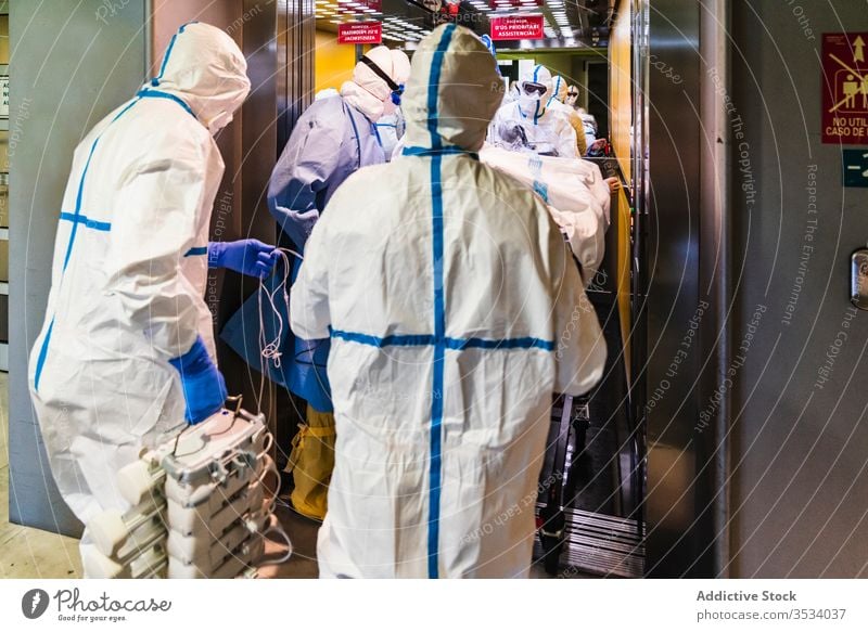 Group of doctors in protective uniform taking patient from elevator group clinic hospital health care mask job specialist equipment medicine treat staff