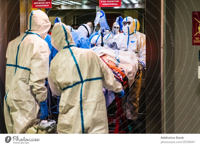 Group of doctors in protective uniform taking patient from elevator group clinic hospital health care mask job specialist equipment medicine treat staff