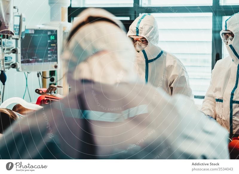 Doctors in protective uniform working in operating room in hospital doctor clinic viral patient care infection equipment treat specialist mask health care