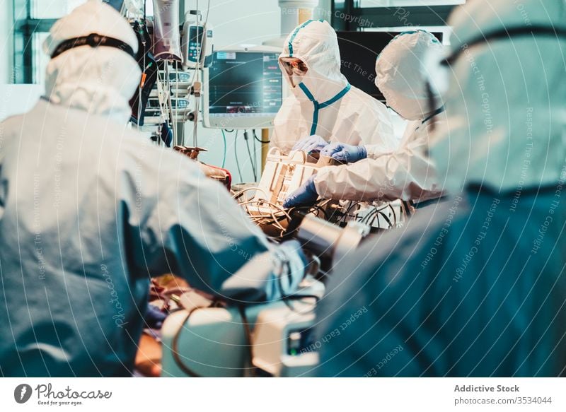 Doctors in protective uniform working in operating room in hospital doctor clinic viral patient care infection equipment treat specialist mask health care