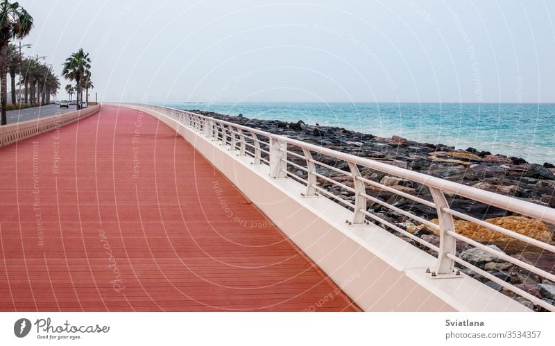 Beautiful promenade with walkway and white fence. breakwater stones sea beach blue sky landscape tourism coast nature ocean travel vacation view beautiful sand