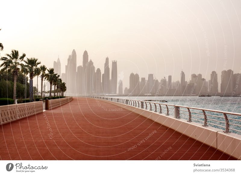 Stunning views of the skyscrapers in Dubai at dawn. UAE breakwater stones sea beach blue sky landscape tourism coast nature ocean travel vacation beautiful sand