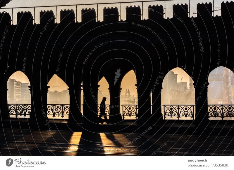 A man on his way to work arch arches architecture beautiful Berlin brick bridge building capital capital cities city colonnade daytime dramatic light famous