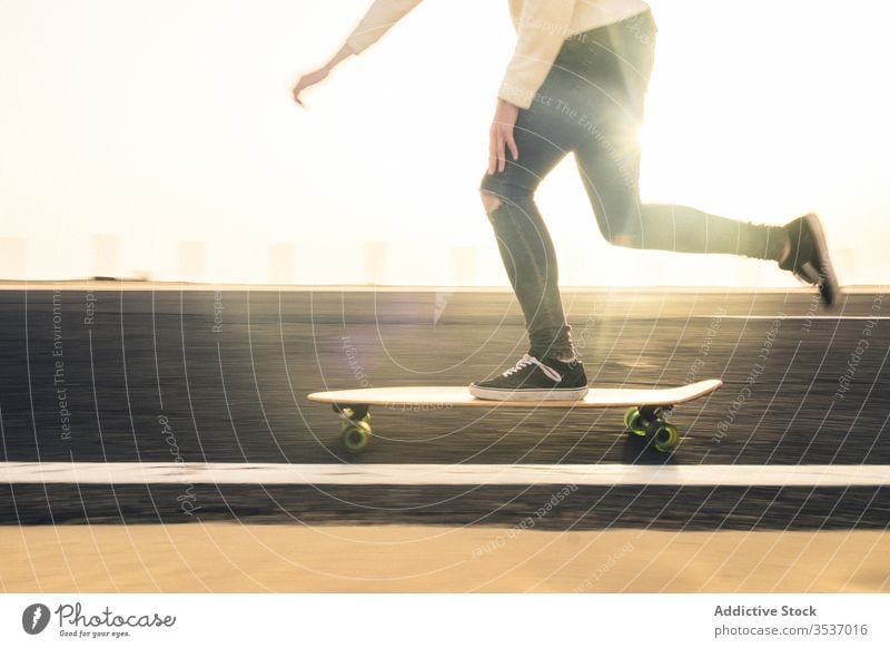 Crop man riding skateboard on road ride evening casual hobby fast fuerteventura spain canary islands male trip travel asphalt sport fun cool lifestyle activity