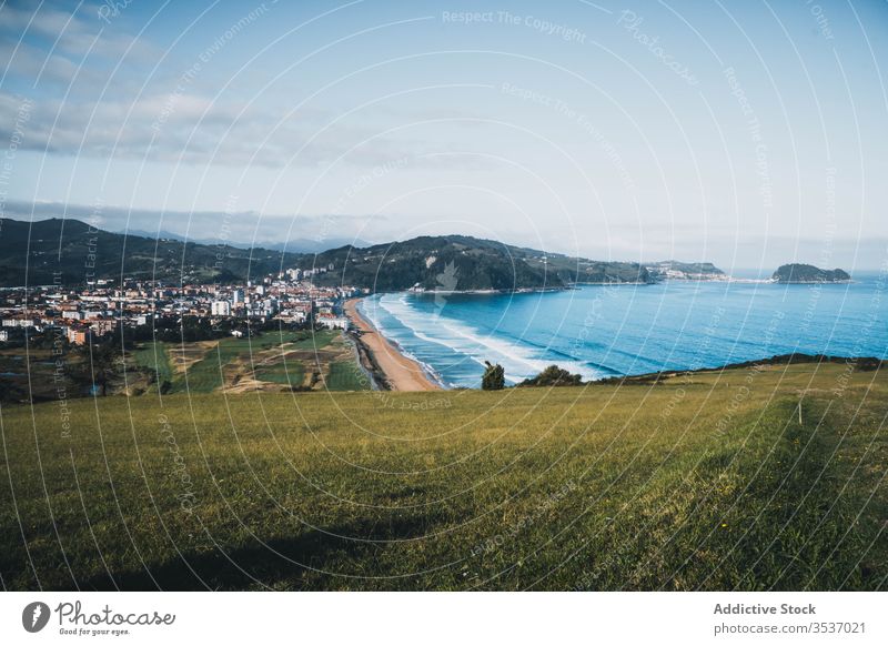 Picturesque view from green hill of seashore and town on sunny day in Spain valley landscape nature coast sky spain picturesque peaceful calm countryside