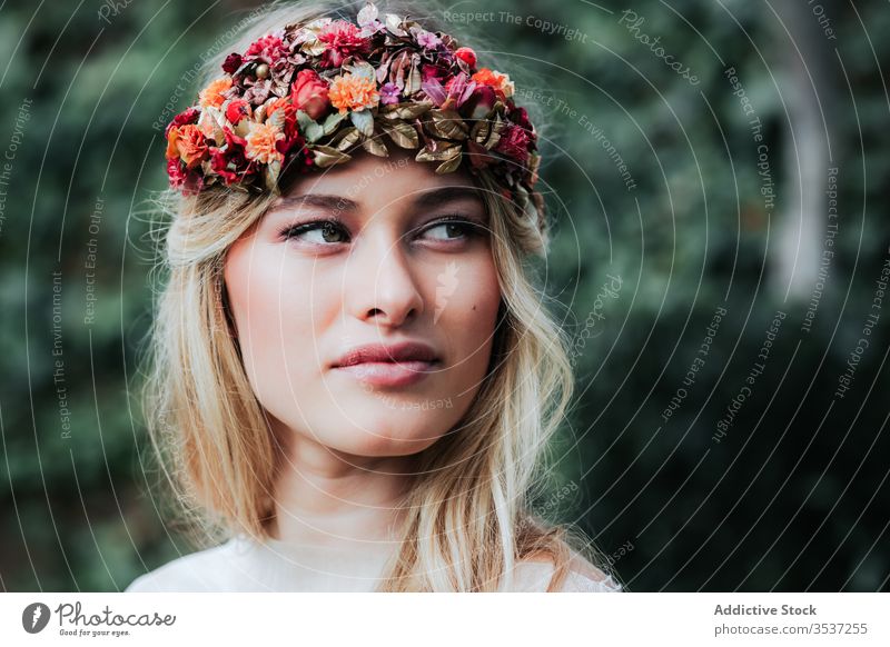 Blond bride resting in yard woman wedding dress wreath flower young elegant translucent floral serene event celebrate sit tranquil calm peaceful blossom tender