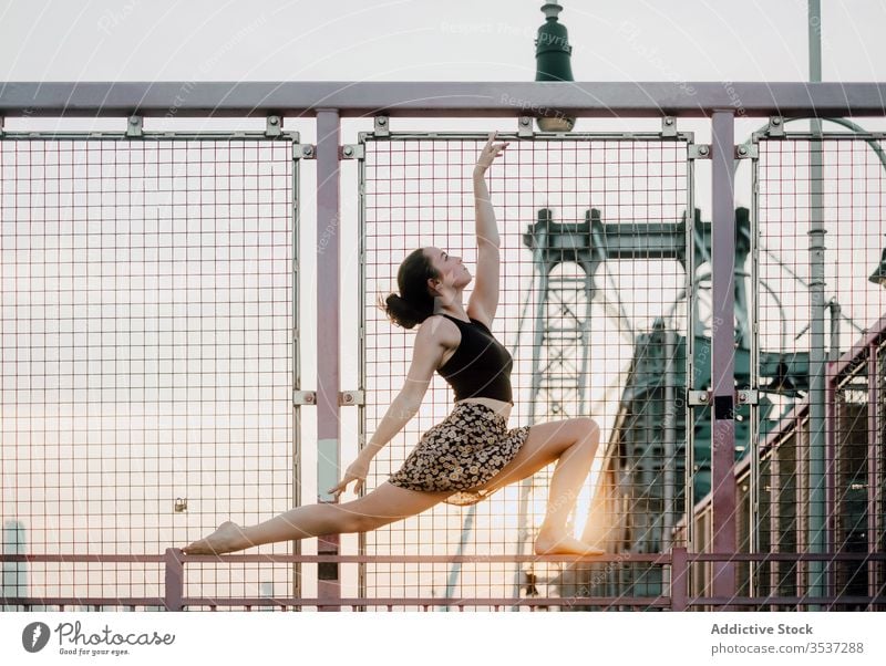 Graceful woman practicing yoga on bridge practice grace serene industrial urban sensual balance crescent lunge pose zen female slim tranquil arm raised calm