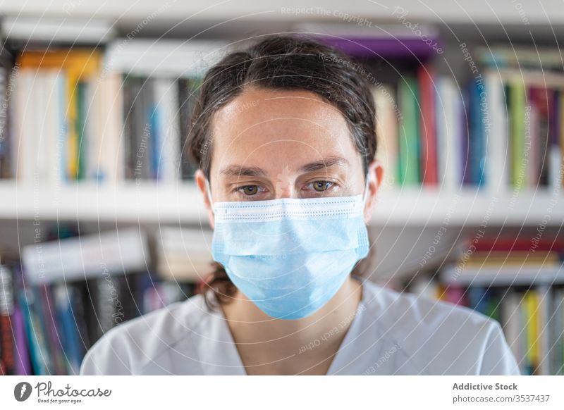 Positive young female doctor in medical mask standing in hospital woman uniform stethoscope clinic covid 19 coronavirus outbreak pandemic office positive