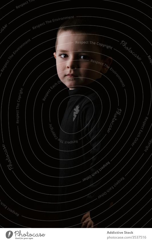 Portrait of cute serious boy on black background little kid pure charismatic portrait childhood gentle adorable expressive innocent cheerful style confident