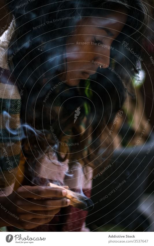 Ethnic woman meditating with smoking sage incense ritual spirit meditate smoke ethnic concentrate calm ceremony tradition burn tranquil shaman serene religion