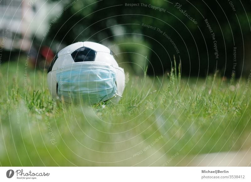 Soccer football with face mask for sports during covid-19 pandemic Football concept corona covid19 danger epidemic field game grass health hygiene natural