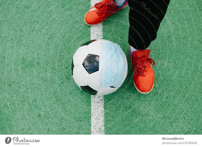 Kick off with soccer football with face mask for sports during covid-19 pandemic Foot Football Soccer artificial concept corona covid19 danger epidemic feet