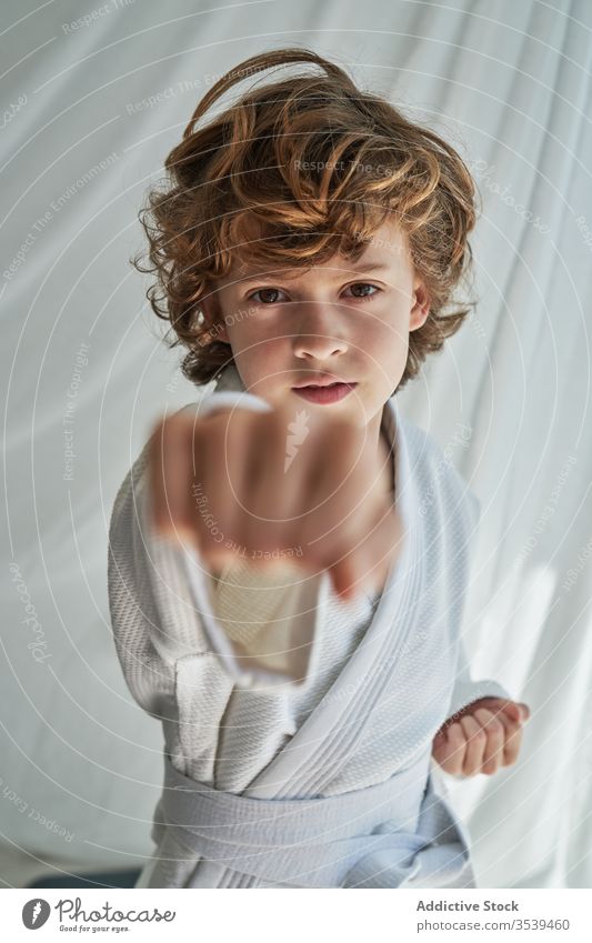 Young boy in white kimono practicing judo at home training belt martial studio focused determine confident sport positive young childhood punch motivation fist