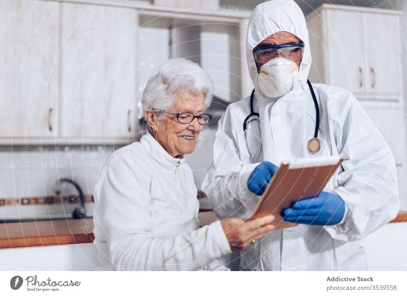 Medical specialist explaining prescription to senior patient during quarantine coronavirus tablet home doctor care medical browsing practitioner health care