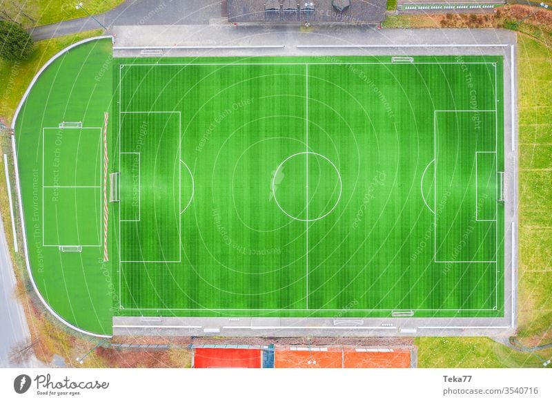 a green empty soccer field from above soccer field goal soccer goal lines sport sport place small soccer field grass sun shadow sports running track ash field