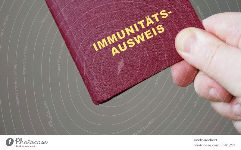 german immunity pass or passport - hand holding mock-up european immune certificate travel document corona coronavirus covid-19 germany immunization pandemic