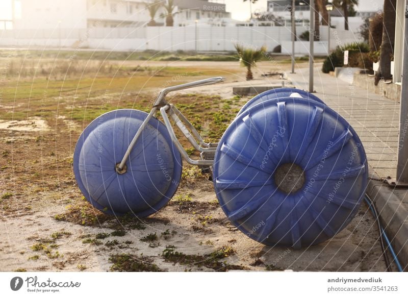 a large homemade bicycle exhibit stands near hotels in a tourist town. selective focus. retro vintage bike wheel transportation ride vehicle old white isolated