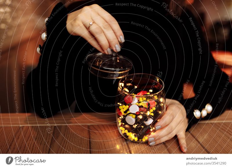 young woman showing bottle of medicine. colored capsules. Different medicinal capsule spill out of a glass. medicine concept pills background pharmacy