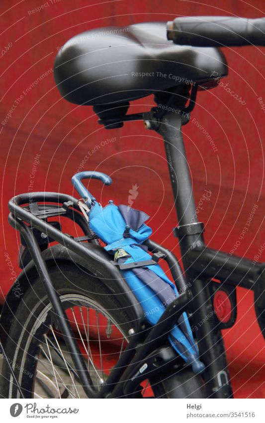 there could be rain - detail view of a black bicycle with a blue umbrella, which is stuck on the luggage rack Bicycle Transport Netherlands Cycling