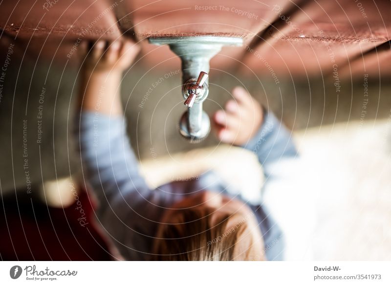 Boys and technology - fascination Child Toddler Garden Tap Water Drops of water Observe Cute water scarcity Drought look at too Wall (building) Wooden wall