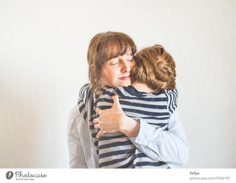 Young mother and child hugging. Mothers day mom parent mothers day woman lifestyle kid love son together family emotion feelings face eyes caucasian happy