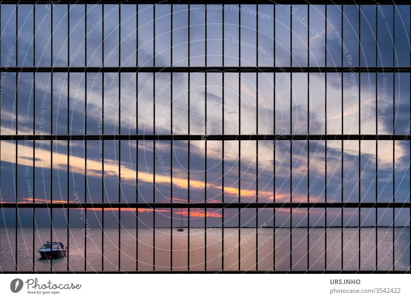 wanderlust but no freedom | the beautiful sunset at the sea hides behind bars Sunset Grating Ocean Horizon closed nature no passage Clouds calm sea Sky Water