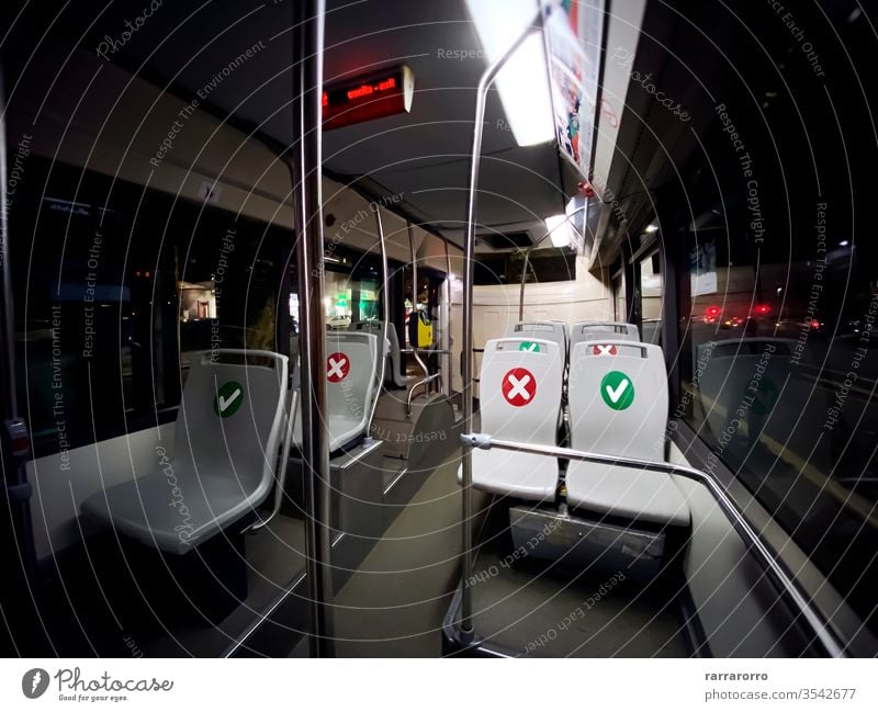 interior of a public transport bus with empty seats with the indication of where is possible to sit social distancing coronavirus covid-19 safety transportation