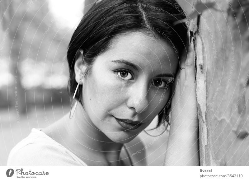 young woman with melancholy gaze leaning against a tree girl tattoo nice beauty cool hipster cute dark hair nature lifestyle people human portrait poses fashion